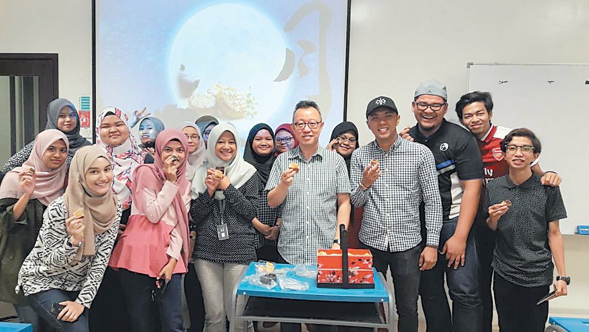 李锡锐（中）与玛拉工艺大学的马来学生一起品月饼过中秋，他也向学生讲述了中秋节的美丽传说。