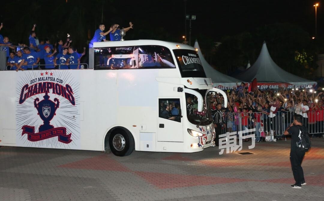 柔佛达鲁达克钦球队队员，在开蓬巴士上向支持者挥手致意。（拍摄：刘维杰）