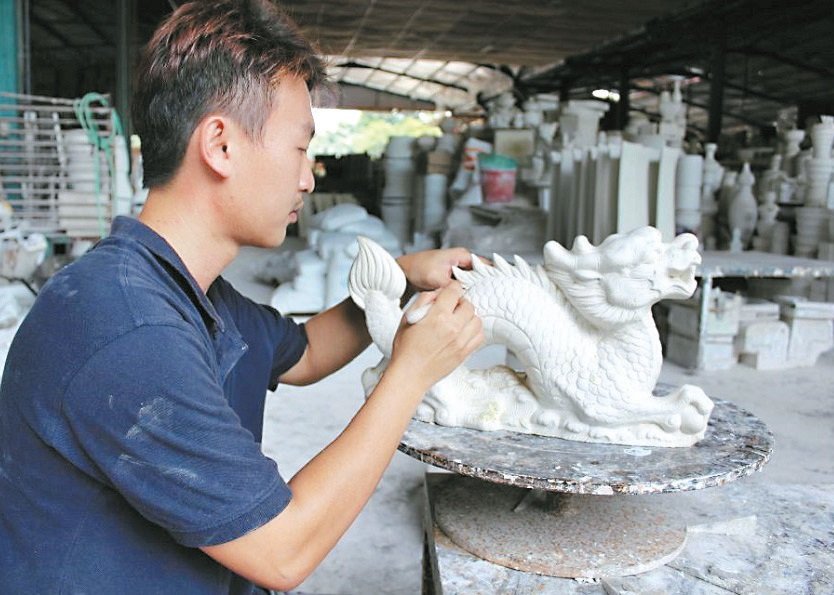 陶瓷业者求新求变，紧贴市场需求。图为郑宇量为龙形陶瓷进行雕刻工作。