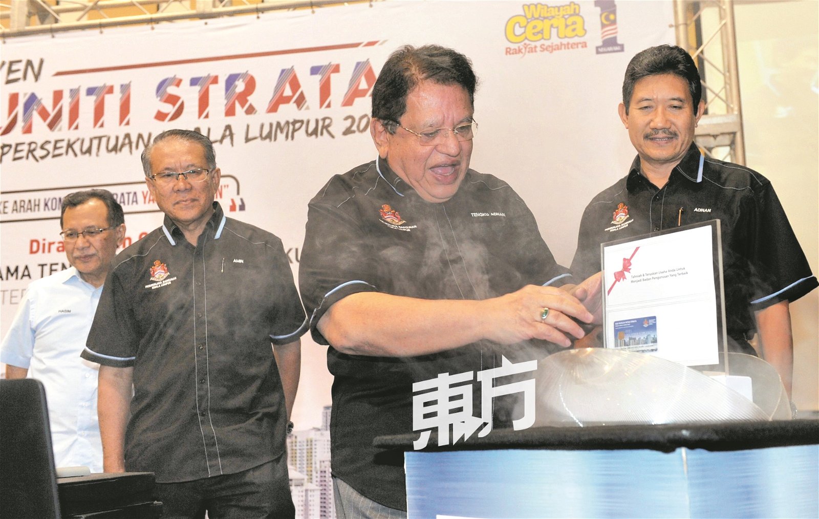 东姑安南（右2）推介吉隆坡市政局“建筑管理资讯系统”的精明卡。左起为哈辛依斯迈、阿敏诺丁与安南依山。（摄影：陈为康）