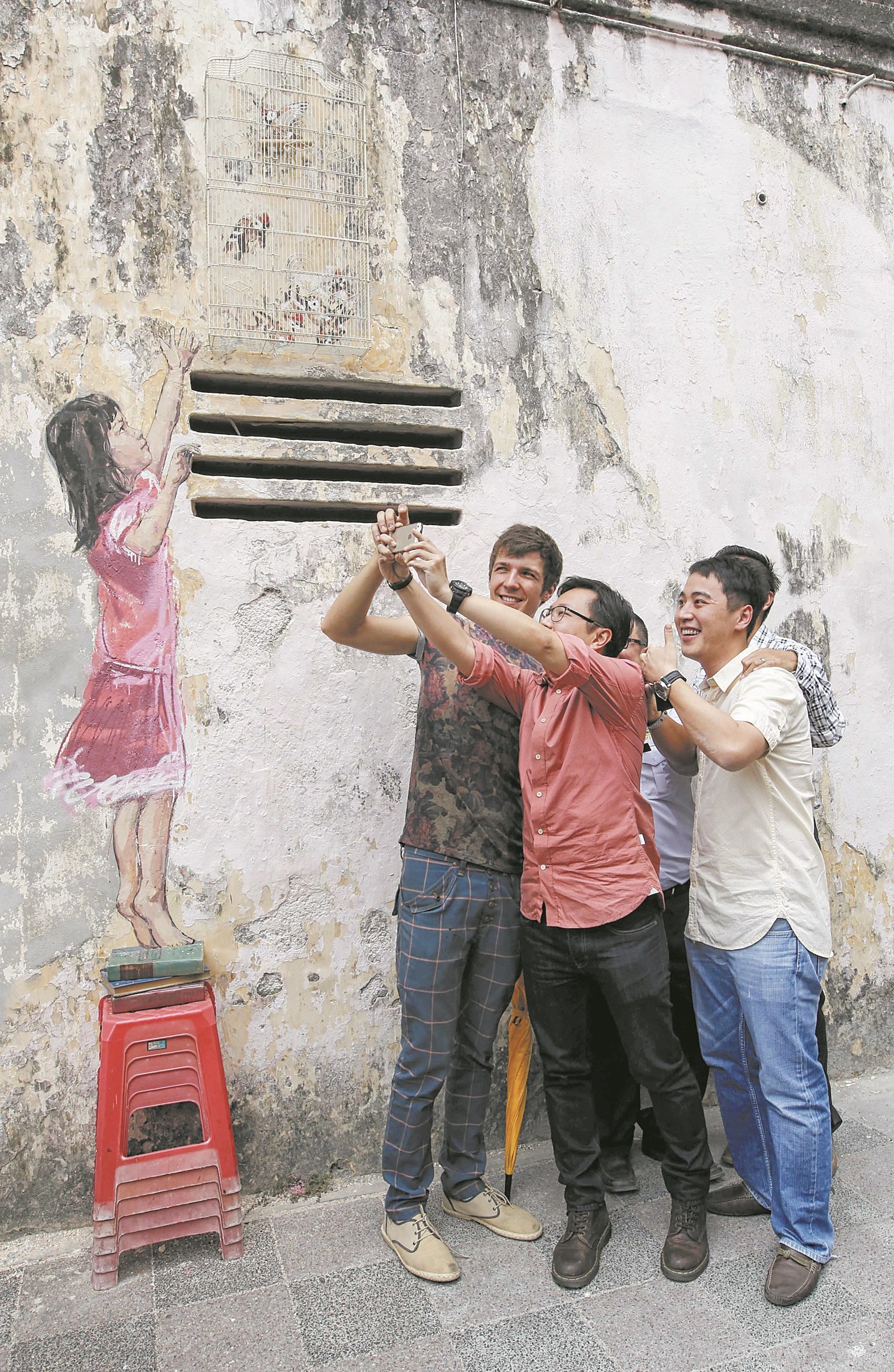 尔纳斯3年前在壁画完成的推介礼上，还与路人在“小女孩与鸟笼”壁画前自拍，惟此壁画如今经已消失。（档案照）