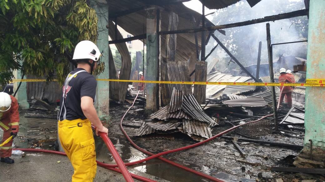消防拯救人员快速进入火灾现场，高举水喉灭火。