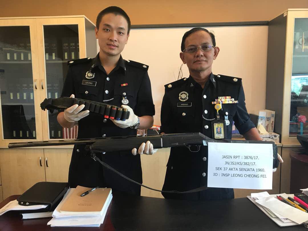 阿尔萨（右起）及梁昌辉展示充公的枪支及子弹。