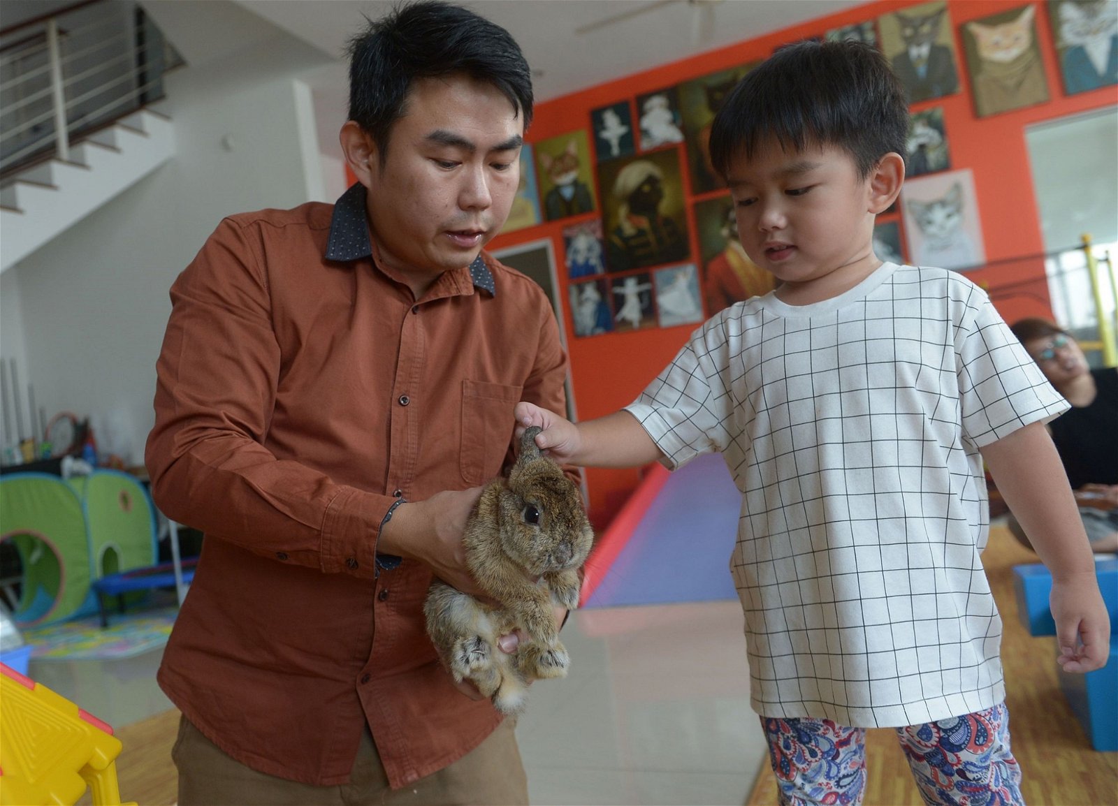 邱逸俊（左）是一名动物治疗师，他透过治疗动物的帮助，跟进特殊儿童的身心行为问题。