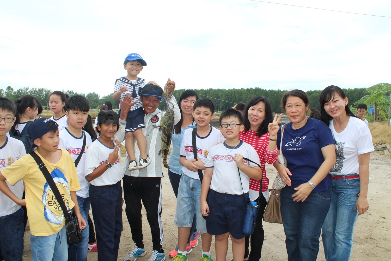 李瑞忠（右7）首次开放养殖场让育智华小师生参与，好让他们有机会了解红树林及鱼类生态。