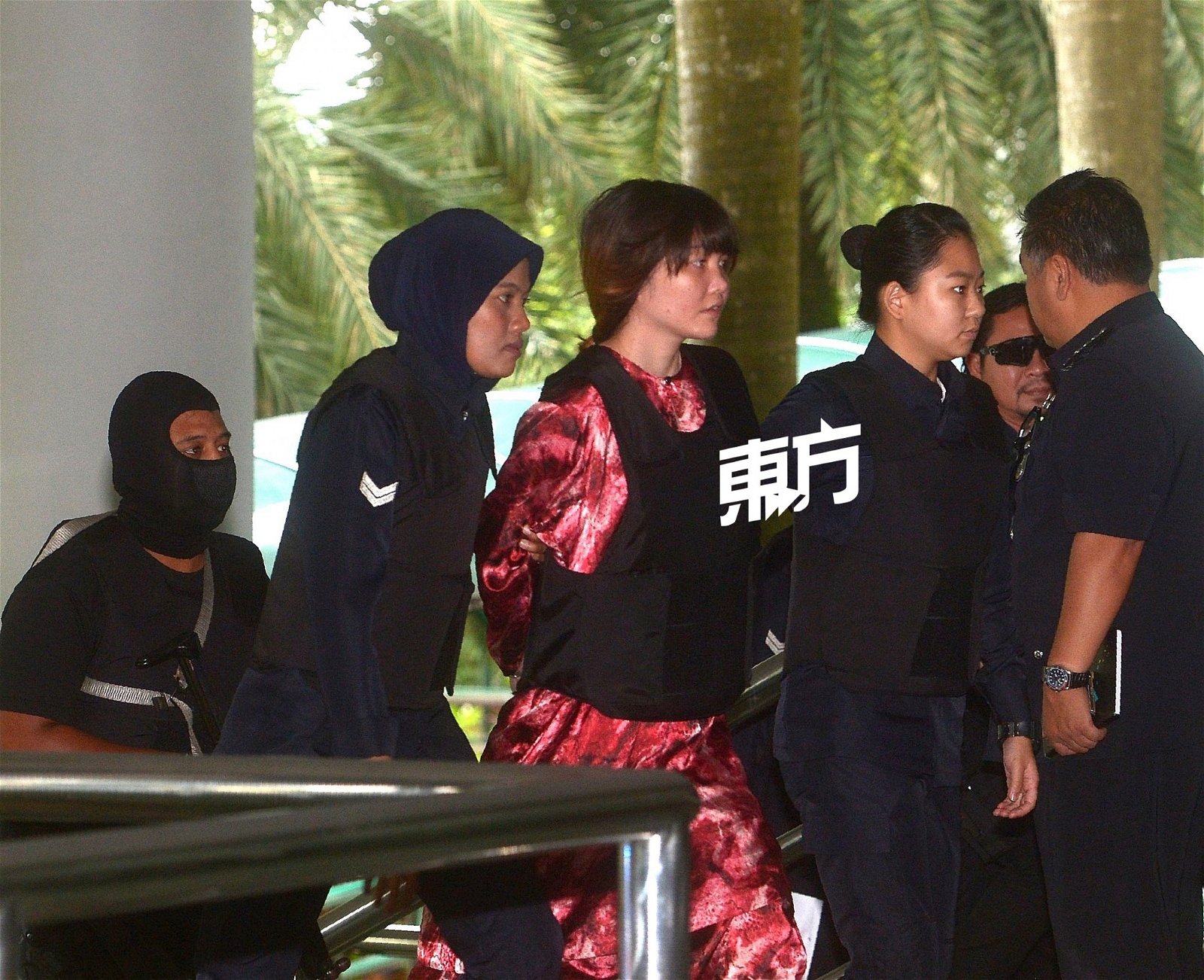 越南籍被告段悌香（中）在特警和女警的押送下，抵达莎阿南法庭出席案件审讯。 （摄影：陈启新）