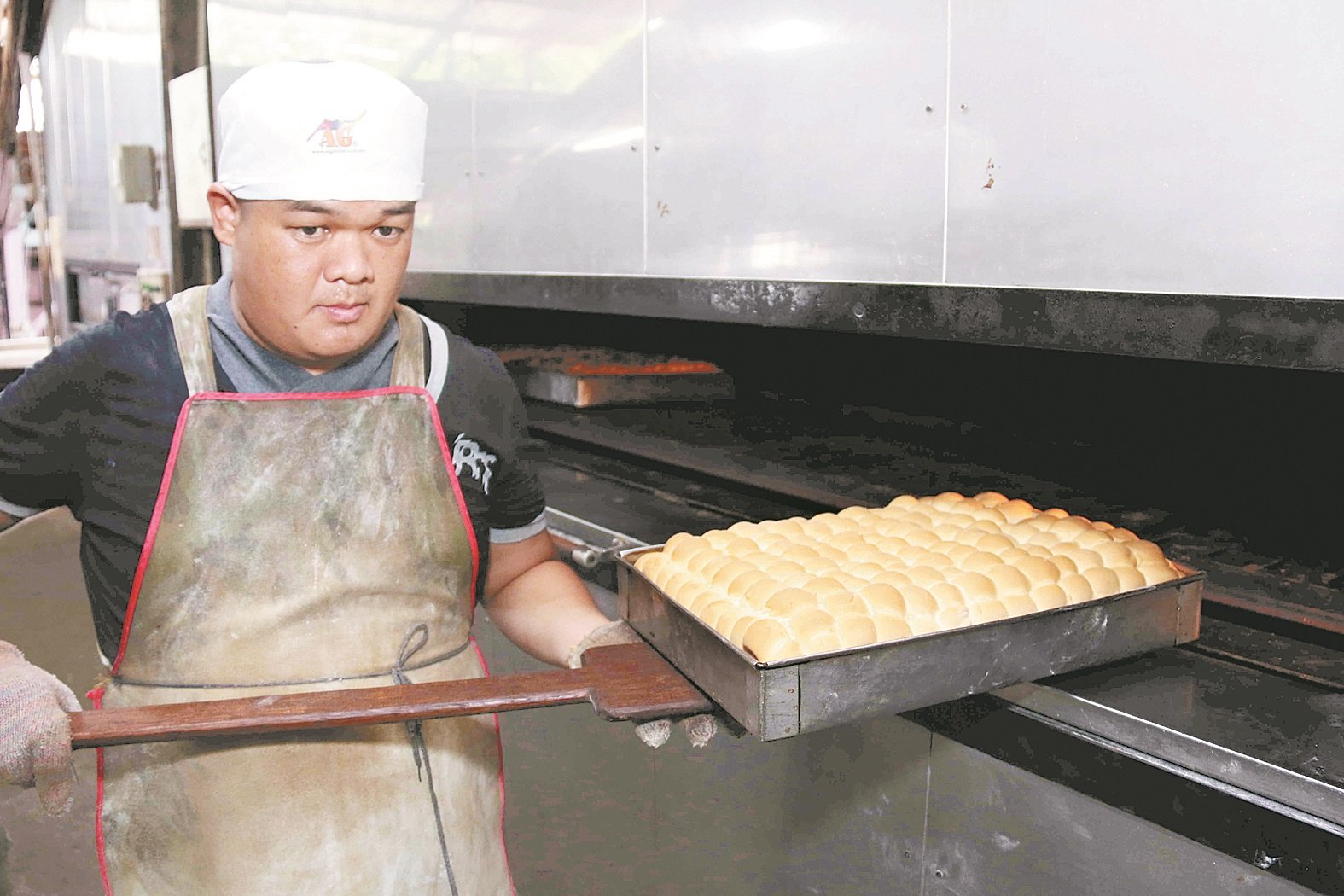 琼源香员工从电炉内取出刚烘培好的白面包。