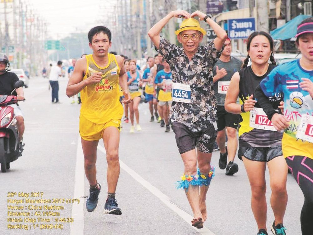 邓华成（左2）在42岁时才开始跑步，在这18年来，他以赤 足和特殊服装参与国内外共125场马拉松赛事。