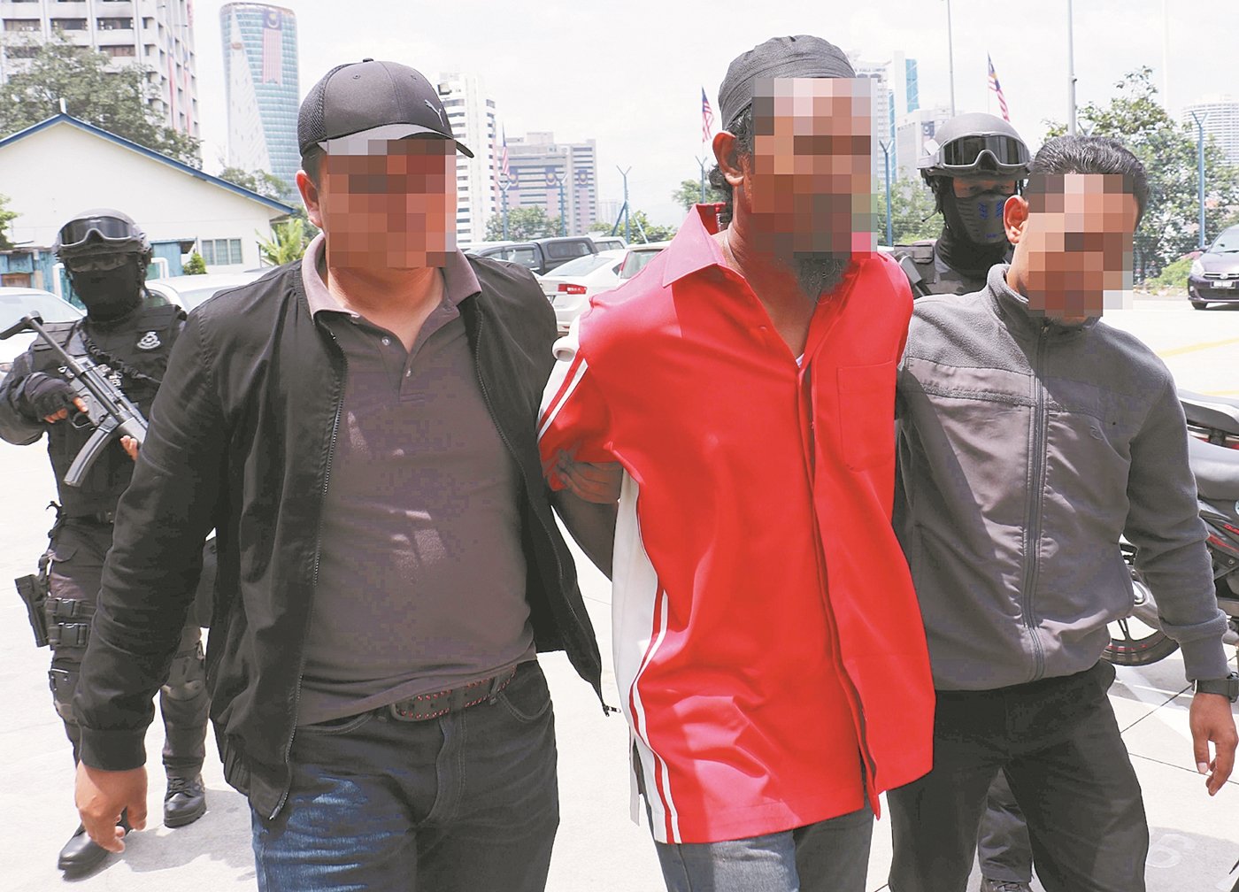 涉嫌印刷与派发IS组织旗帜的男嫌犯（左3）遭全副武装的反恐组成员逮捕。
