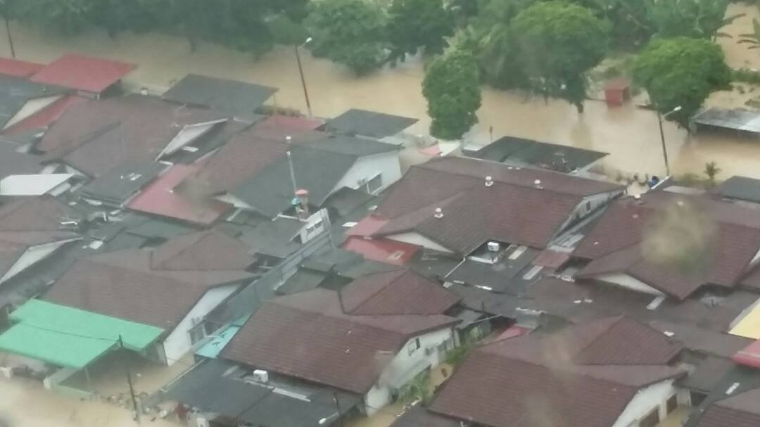 眼看灾水逐渐上升，有两名住在亚依淡天德园路的居民乾脆爬上屋顶，等待救援。