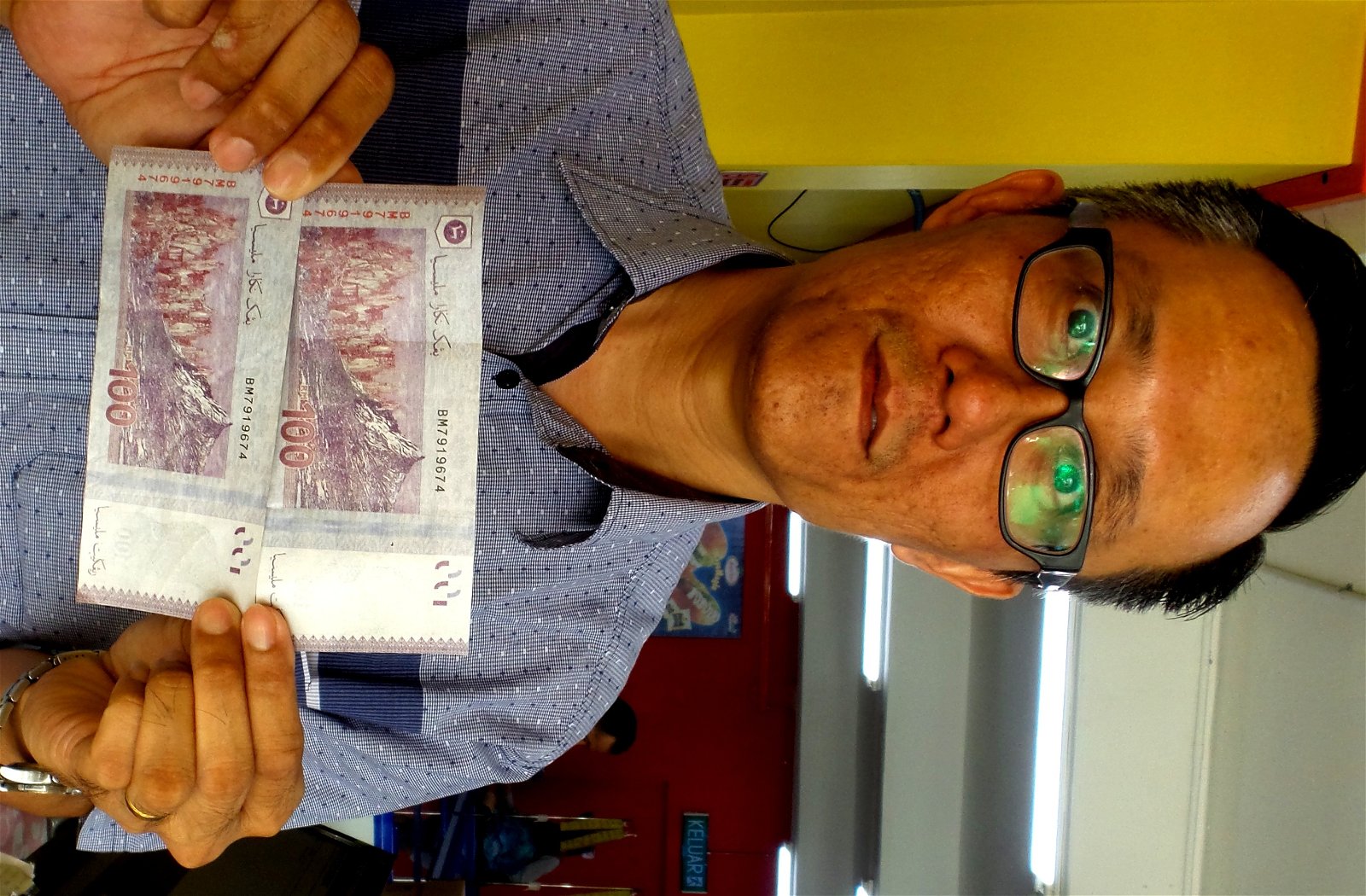 廖政光出示所收到的同序号100令吉伪钞。