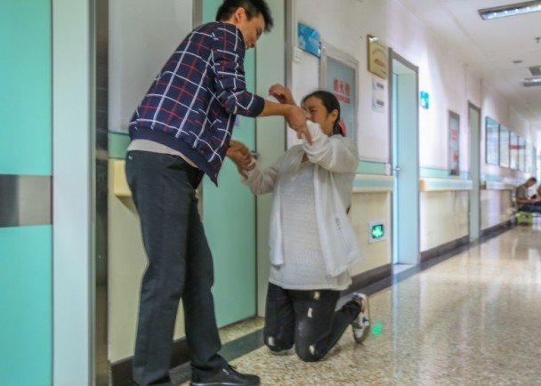 浩宸的母亲在医院跪谢志愿者送来的捐助。