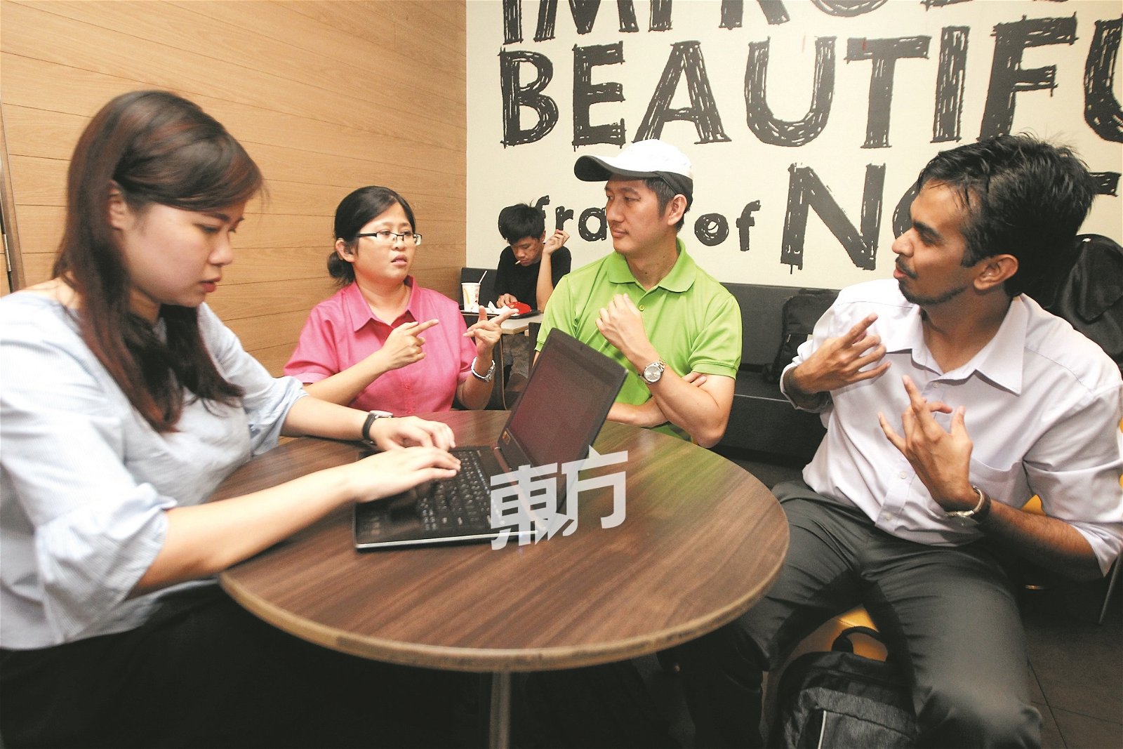 本报记者廖诗弦（左）透过笔记型电脑输入问题，向听障人士Esther（左2起）、凯文及亚当提问。（摄影：伍信隆）