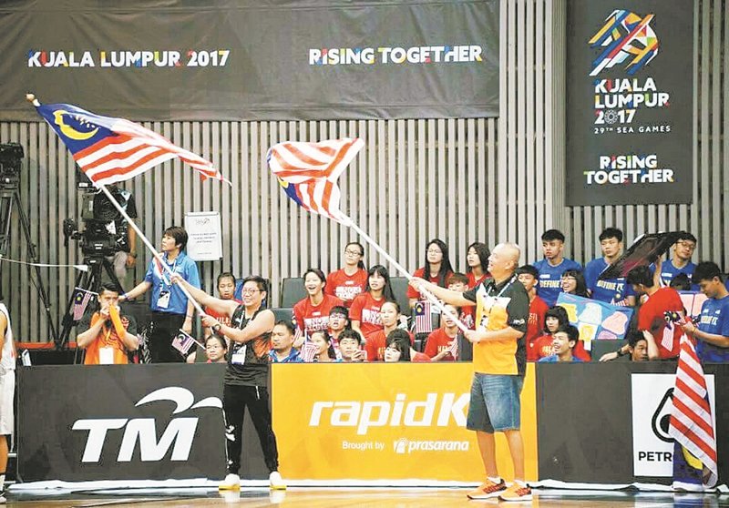 赖俊瀚（前左）热爱篮球运动，在刚落幕的 吉隆坡东运会，到场为大马女篮挥旗打气， 而女篮也不负众望，成功蝉联冠军。