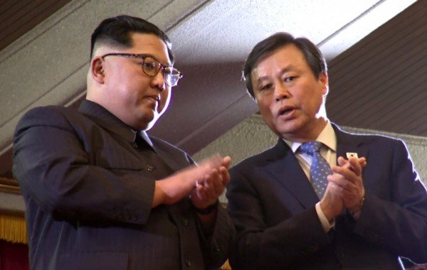 朝鲜最高领袖金正恩（左）在看台上鼓掌，并与韩国文化体育观光部长都钟焕交谈。