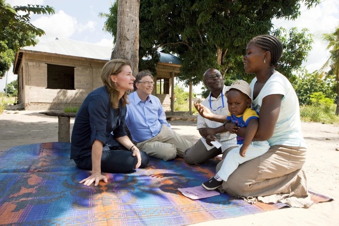 盖茨夫妇一直在从事慈善事业，这是两人在坦桑尼亚，与一名参与疟疾疫苗测试的民众见面，聆听对方的经验。