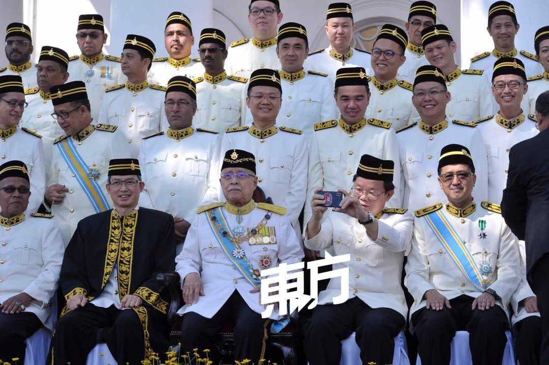 面对大批媒体竞相拍摄州议会开幕的珍贵照，首长曹观友（坐者右2）也拿起手机反拍媒体，流露有趣的一面。（摄影：蔡开国）