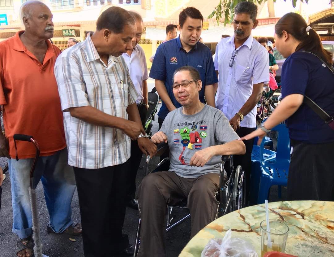 古拉（前左）代表热心人士赠送轮椅给有需要的怡保市民。