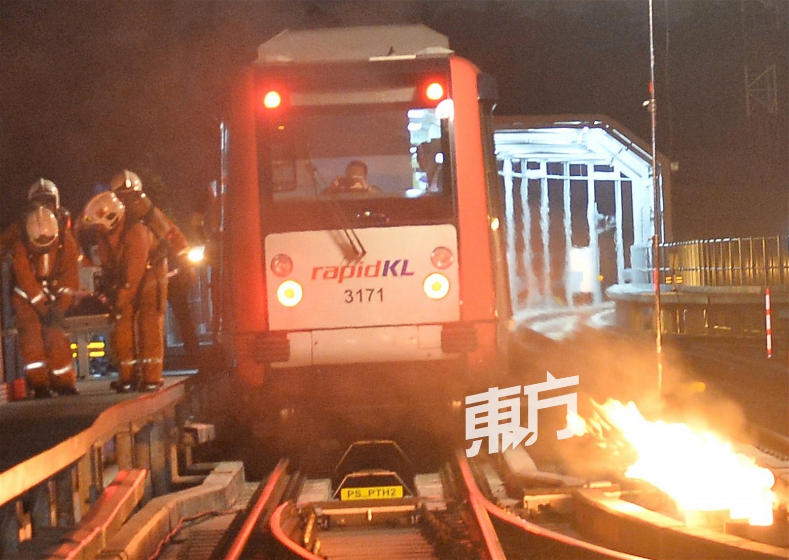 轻快铁列车旁燃起了“熊熊烈火”，消防人员把握时间，把列车上的伤者以担架抬离现场。