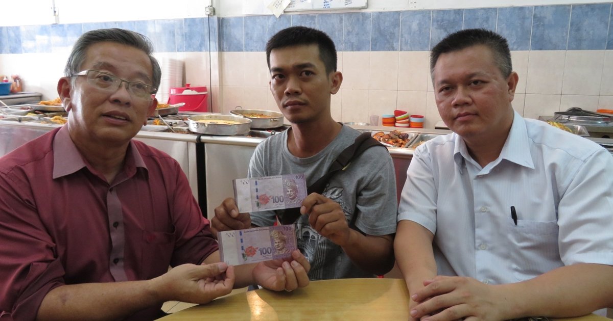 周世扬 （ 左起 ） 、 陈国良与吴金财展示收到的假钞与真钞对比。