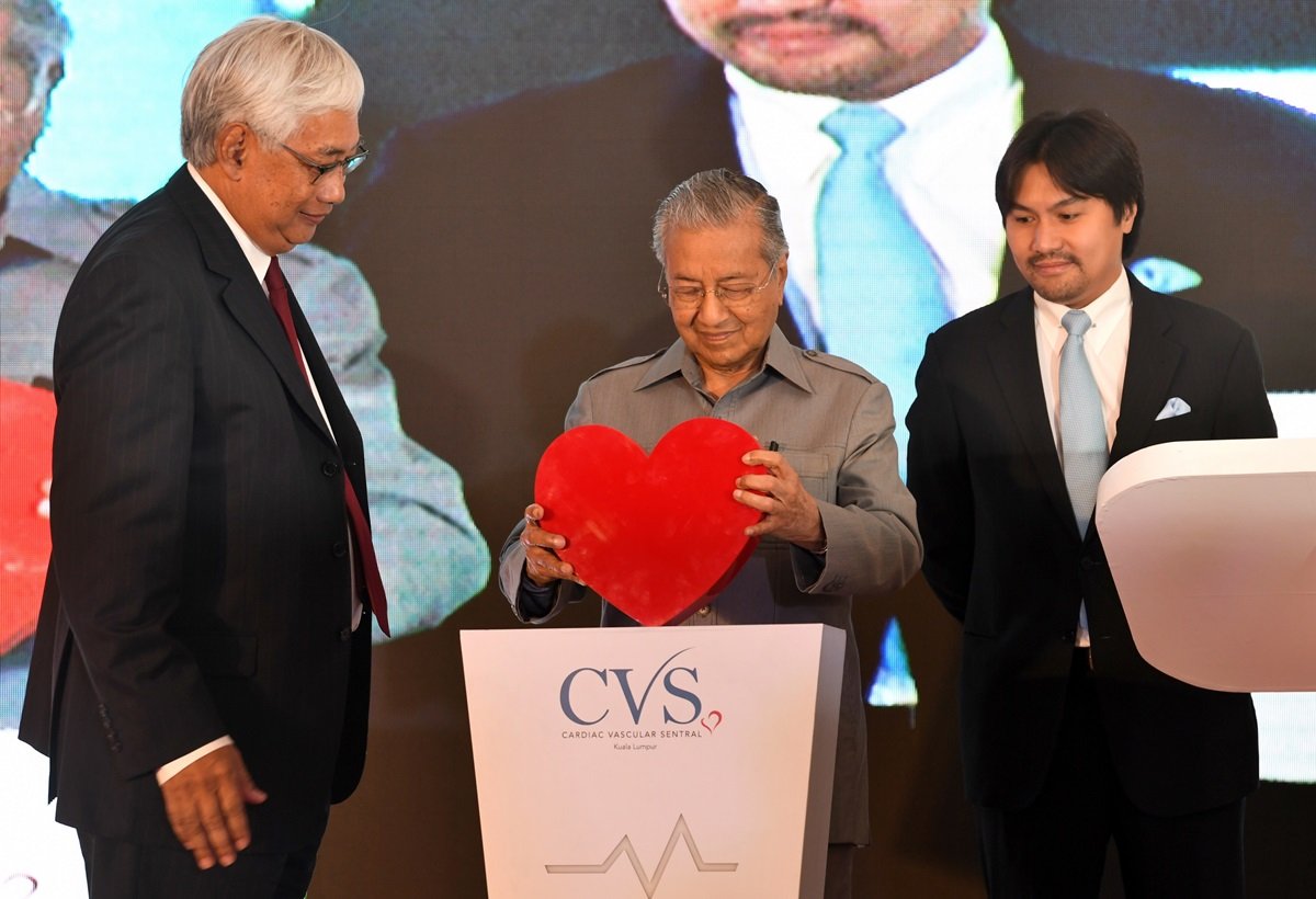 敦马哈迪（右）从雅哈耶阿旺(左）手中接过红“心”，以便为吉隆坡中环心血管专科医院主持开幕仪式。