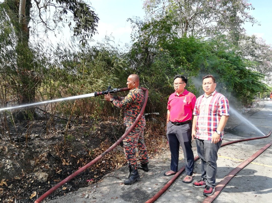 吴国民（右起）和梁德志到巴生港口了解草丛著火的情况。