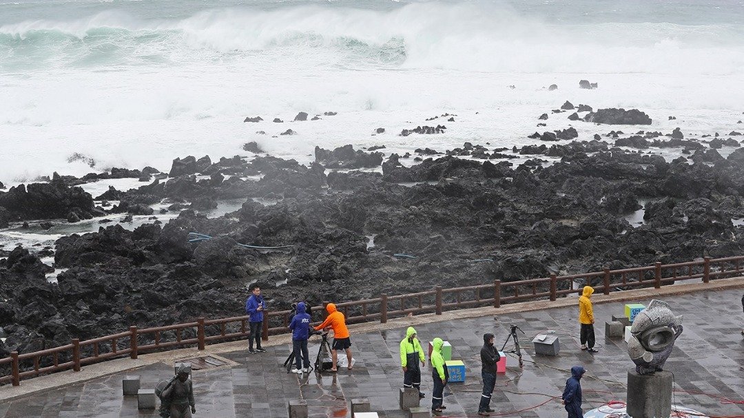 韩国：台风“苏力”吹袭济州岛，在岸边掀起巨浪，一群新闻工作者冒著危险，在海边为气象播报做准备。“苏力”穿过朝鲜半岛后，韩国周五下午脱离台风影响，大部分地区的台风警报解除。