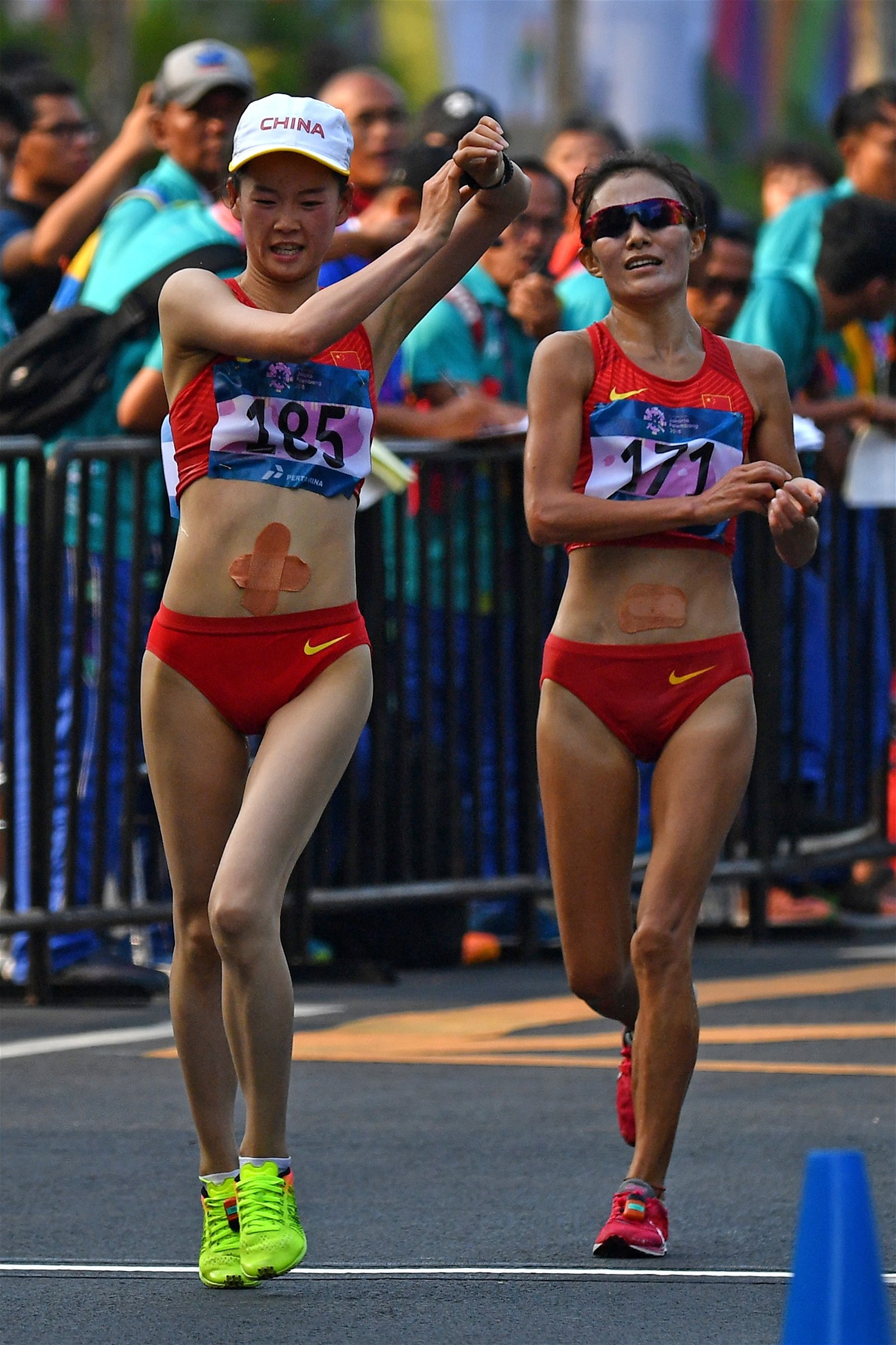 新星杨家玉（左）和老将切阳什姐，以同时打破大会纪录的姿态，为中国完成女子20公里竞走亚运九连冠。