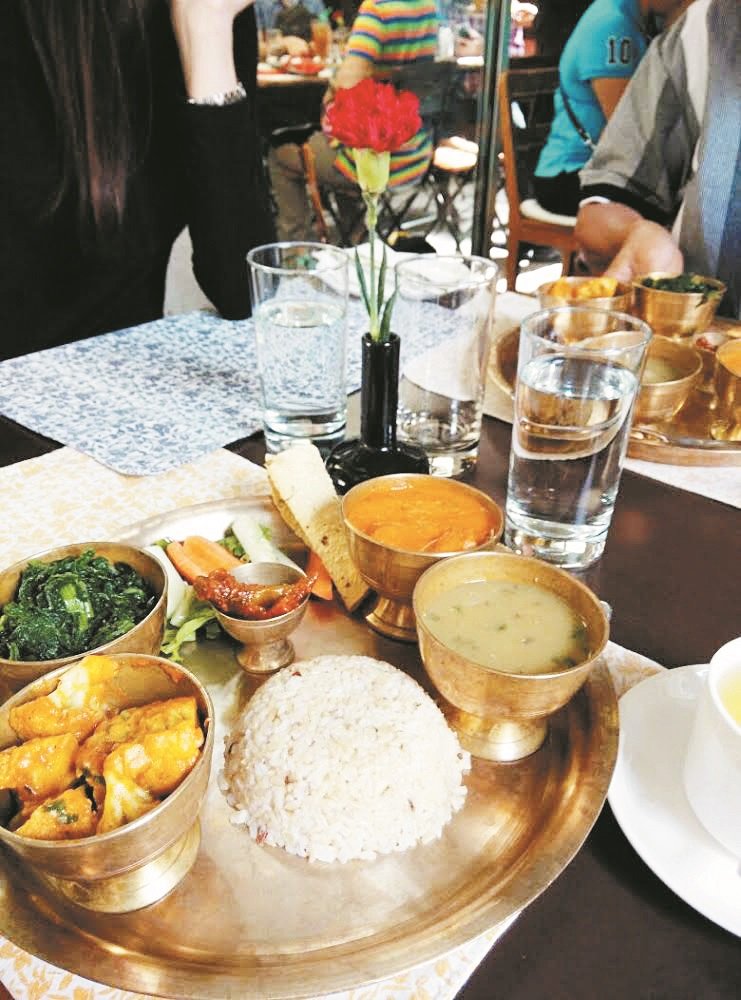 尼泊尔深受印度文化影响，因宗教缘故，该国人民偏好素食。图为团员享用当地特色的素食。