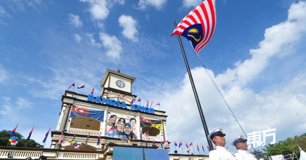 麻坡黄金丹绒广场大钟楼旗海飘飘，图为国歌响起时全场竖立，军官随著国歌徐徐升起国旗。（摄影：杨金森）