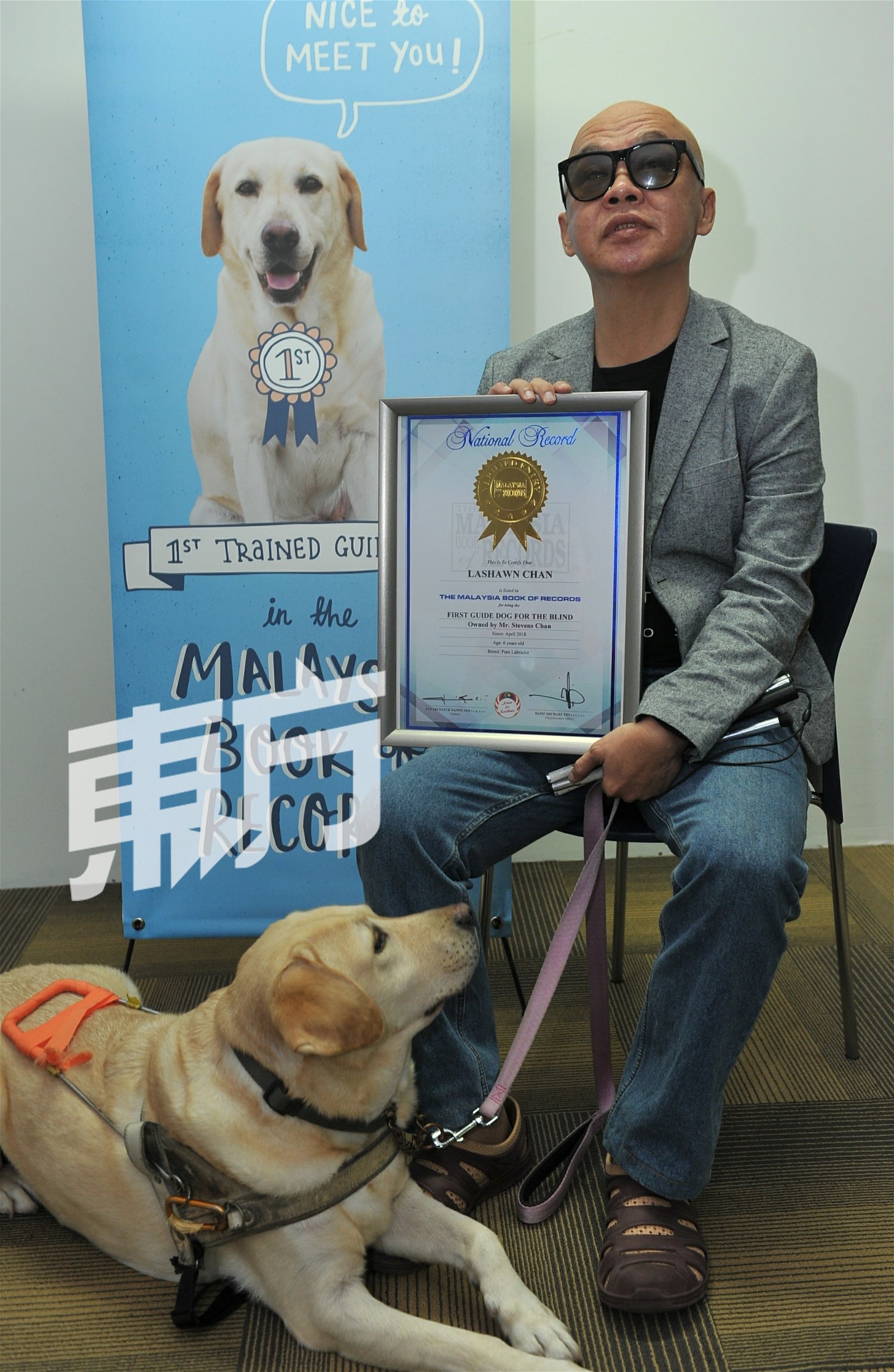 陈锦辉与其被列入马来西亚纪录大全“马来西亚第一 只导盲犬”的导盲犬拉绍恩。（摄影：连国强）