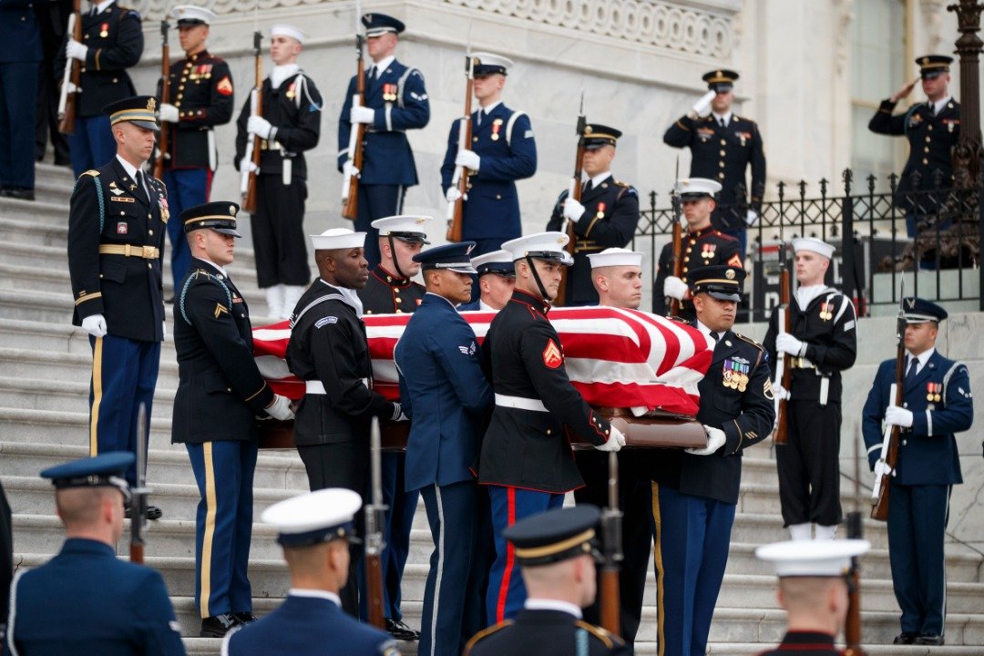 老布什停放在美国国会大厦的灵柩，由美国陆军、海军仪仗队、空军部队及海军陆战队士兵的扶柩下，步下国会阶梯，并送往华盛顿国家大教堂。