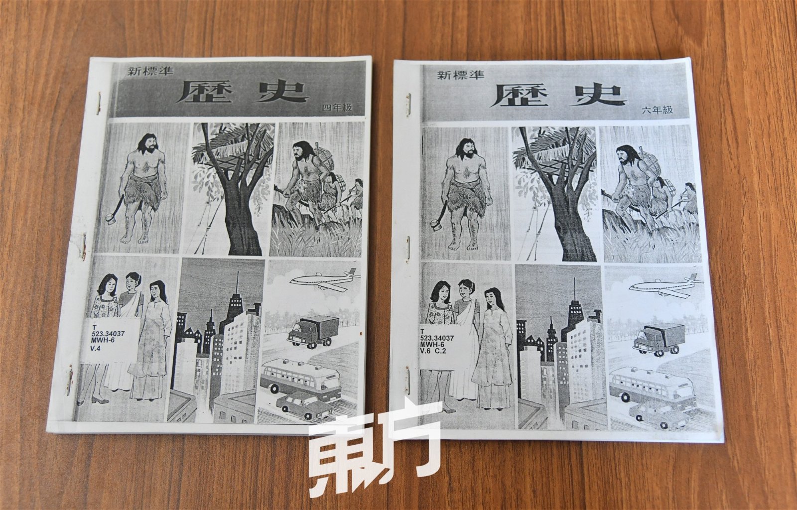 陈亚才向记者展示其收集的小学历史课本，作为研究工作的一部分。 -