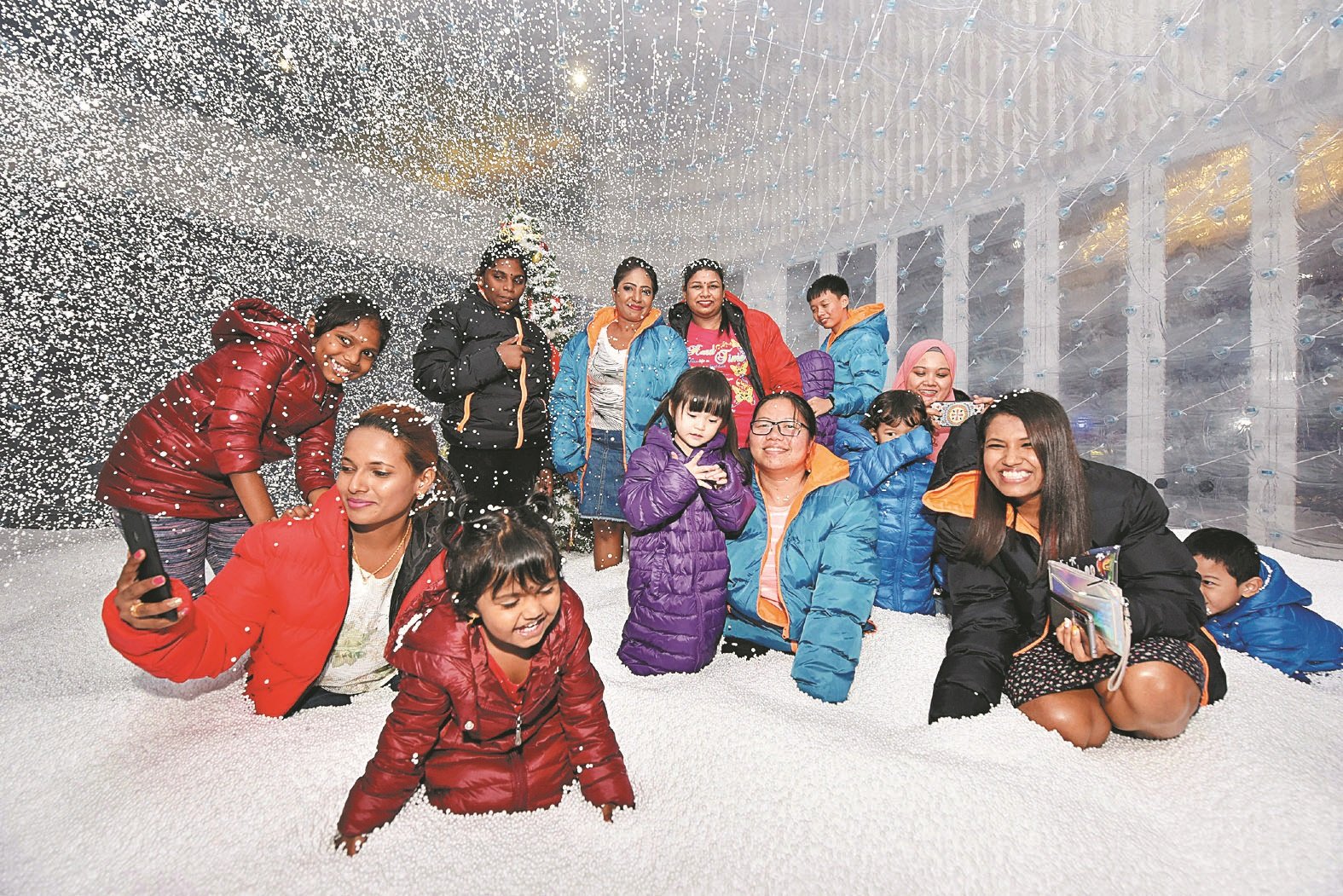 “下雪”情景让大家乐在其中，无论是大人小 孩都玩得不亦乐乎。