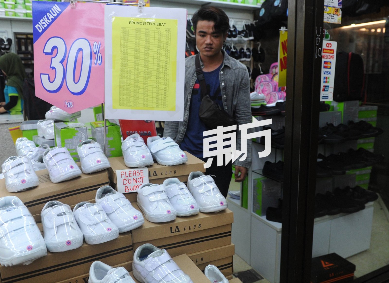 许多商家为白鞋推出折扣优惠，吸引家长前来选购。（摄影：徐慧美）