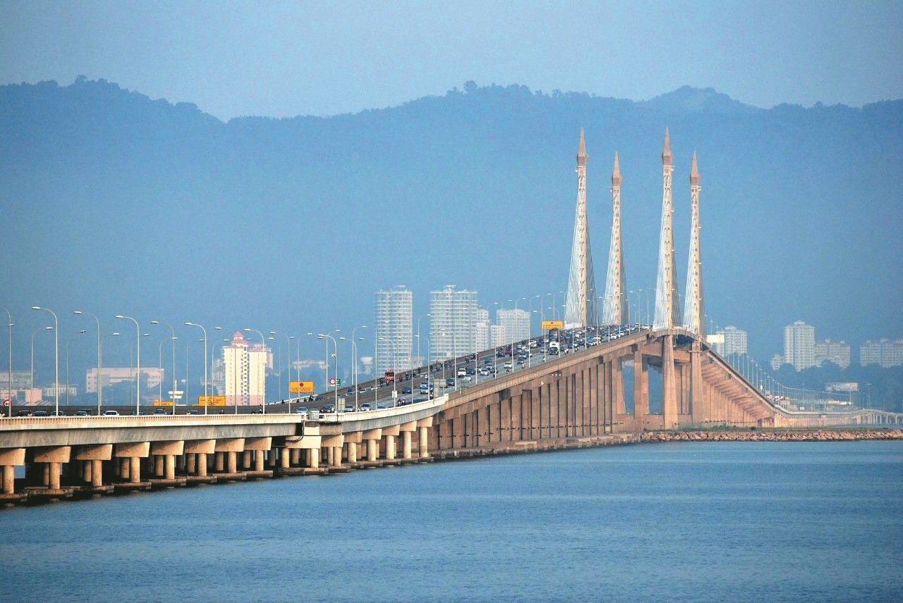 槟城大桥全长13.5公里，从1982年开始建造，并于1985年9月14日正式通车，成为首个连接槟岛和马来西亚半岛的道路通道。槟城大桥在海上的路段有 8.4公里，乃大马第2长、东南亚第5长的长桥。 基于交通流量偏高，槟城大桥有限公司把原有的 双向4条车道扩充至6条车道，工程于2009年8月竣工。目前，每天约有8万辆交通工具（单向）使用 槟城大桥。
