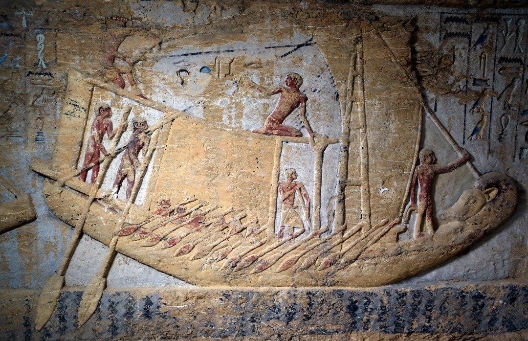 这是刻于墓葬内部墙上的一幅壁画，显示了一群人正划著船桨，在海上航行的场景。壁画的保存度相当完好。