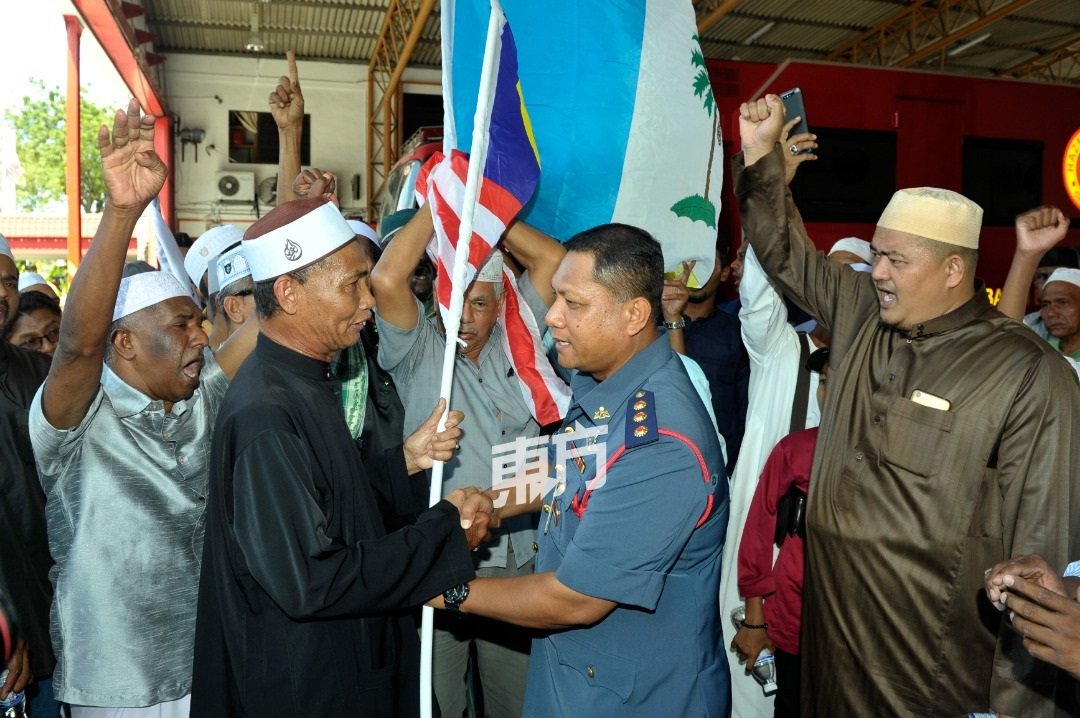 槟州马来青年组织主席尤索夫（左2起）移交国旗给依斯迈，并由阿兹米等人陪同。（摄影：蔡开国）