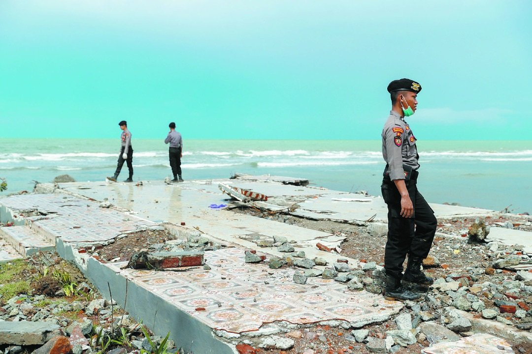 警员们周一在板底兰海边的酒店废墟之间，寻找罹难者。