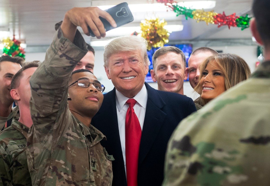 美国总统特朗普和夫人马拉尼亚在拆礼物日突然造访美军驻伊拉克基地，并与士兵们大玩自拍。