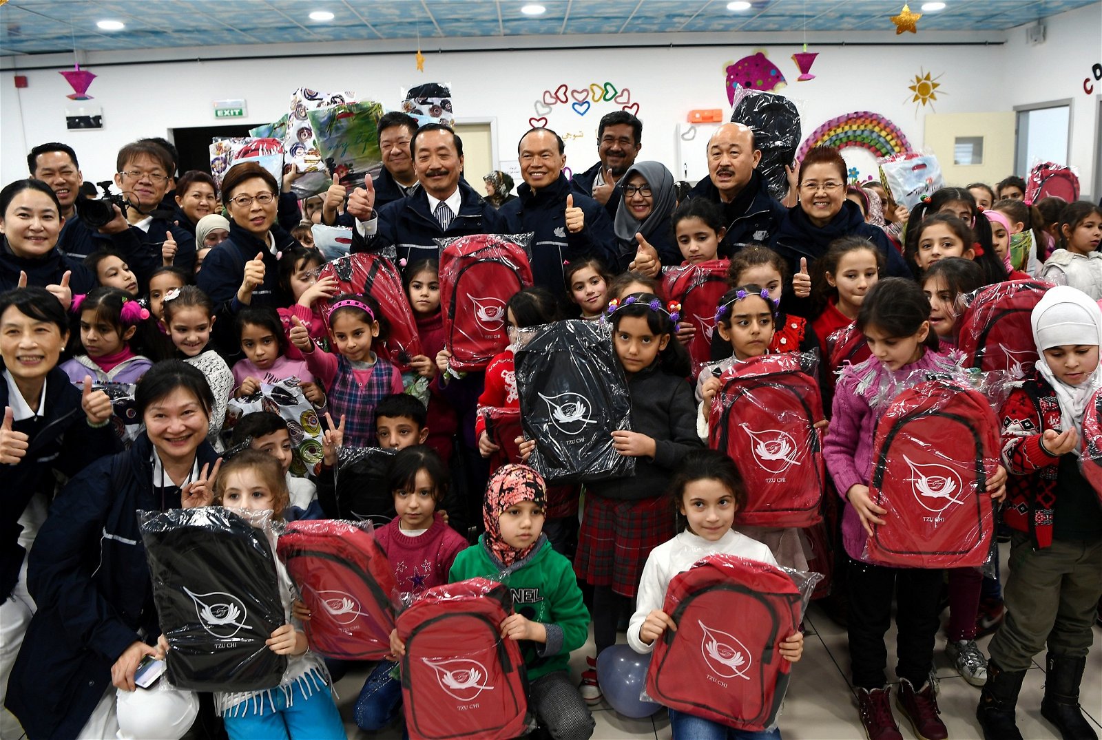 陈志远（后排右6）捐赠书包予叙利亚学童们。后排右5为林伟才。