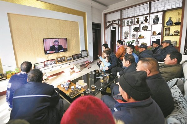 中国在2018年12月18日迎来改革开放40周年，习近平在北京人民大会堂的庆祝大会上发表演说。山东省聊城市的民众坐在电视机前，观看习近平讲话的直播。
