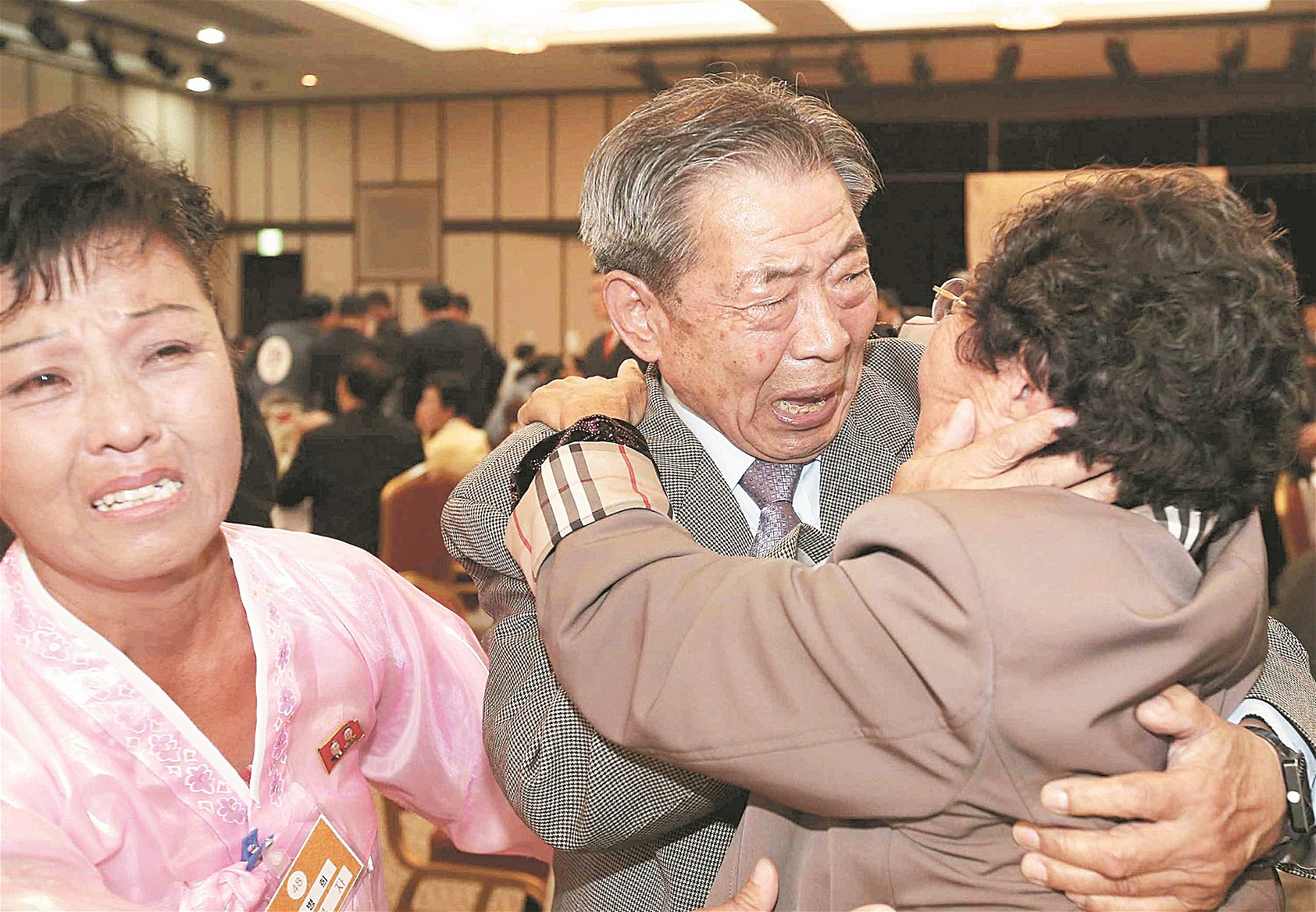 2015年10月20日在朝鲜金刚山举行第20次韩朝离散家属团聚活动上，来自韩国的84岁闵浩植（中、译音），拥抱居住在朝鲜的亲人闵安锡（译音），激动万分，泪流满脸。两人自韩朝分裂之后，超过60年来首次见面。