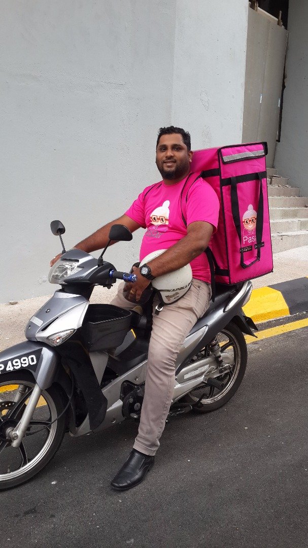 移动网购平台Pasar专属的“粉红骑士”将物品放入保鲜袋中，从巴刹直接快递至客户住家或指定地址。（Pasar提供照片）