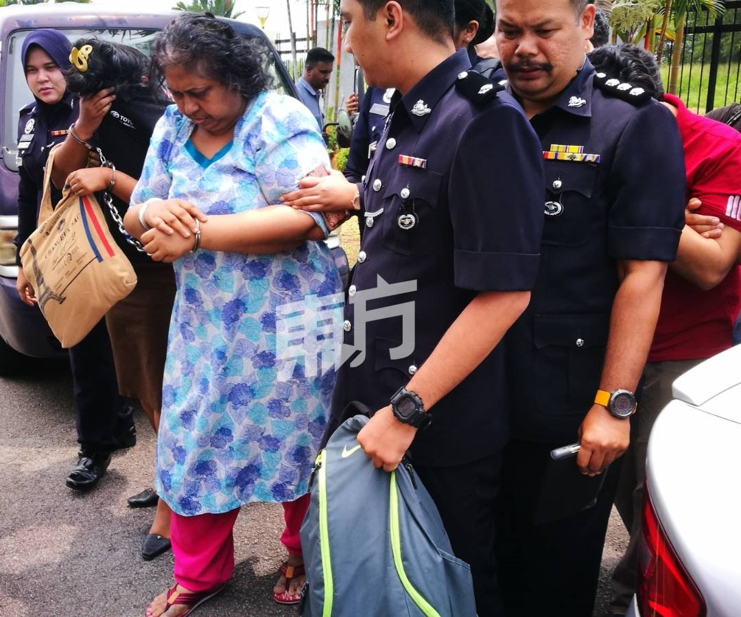 60岁女被告安碧嘉（左3）步履蹒跚，就连步行都需要警员在旁搀扶。其女儿再也华蒂妮（左2）全程以衣服捂脸。（摄影：廖丽宁）