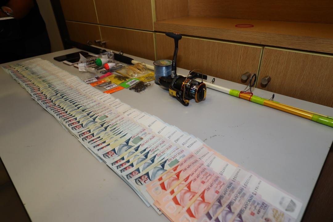 警方在周英汉身上发现约5000新元（约1万4800令吉）现款及钓鱼用具。