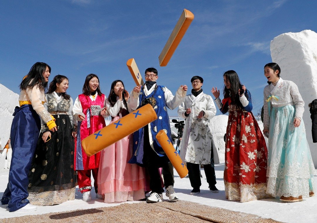 在韩国平昌，一群身穿传统韩服的年轻男女于大年初一玩起传统的过年游戏“掷柶戏”。