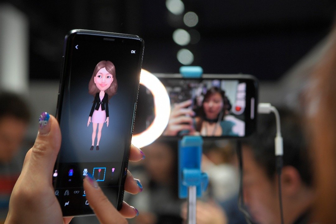 在网络发达的年代，通讯应用程式已成日常生活中不可缺少的一环。三星Galaxy S9和S9+ 推出扩增实境“虚拟人偶”新功能，让用户可创建专属自己的虚拟人物。一名女子在大会上，体验S9中的“虚拟人偶”功能。