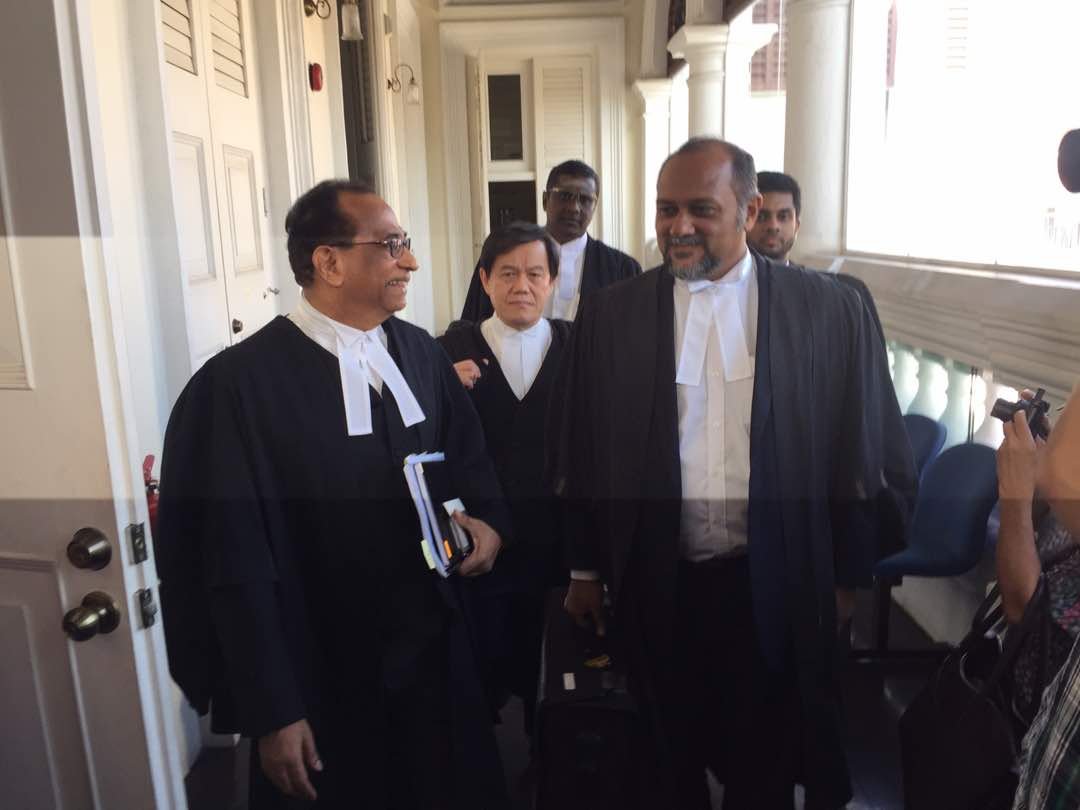 彭丽君代表律师拿督西旦峇南(左)及林冠英代表律师哥宾星（右）步出法庭时，边讨论案件，后为其律师团队。（摄影：吴维康）