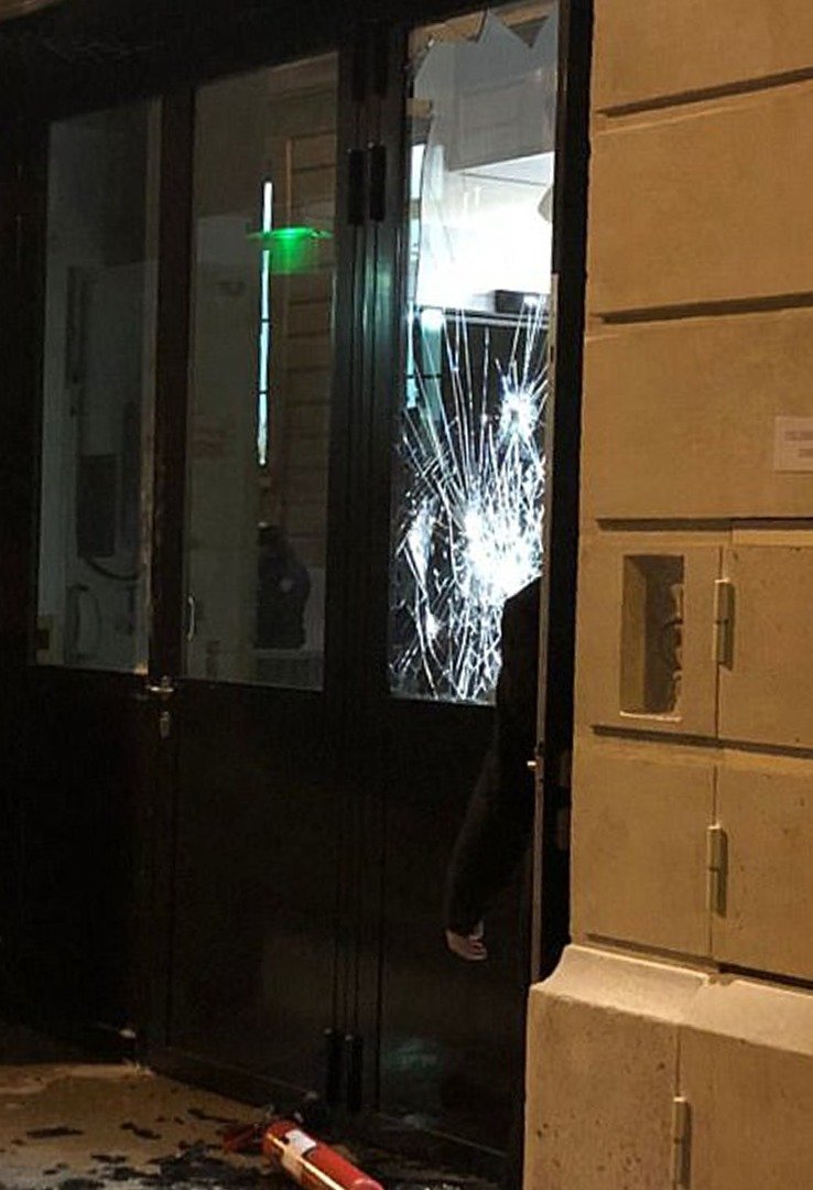 匪徒用斧头和大锤闯入丽思酒店内的珠宝店，玻璃门上可见撞击后留下的裂痕。